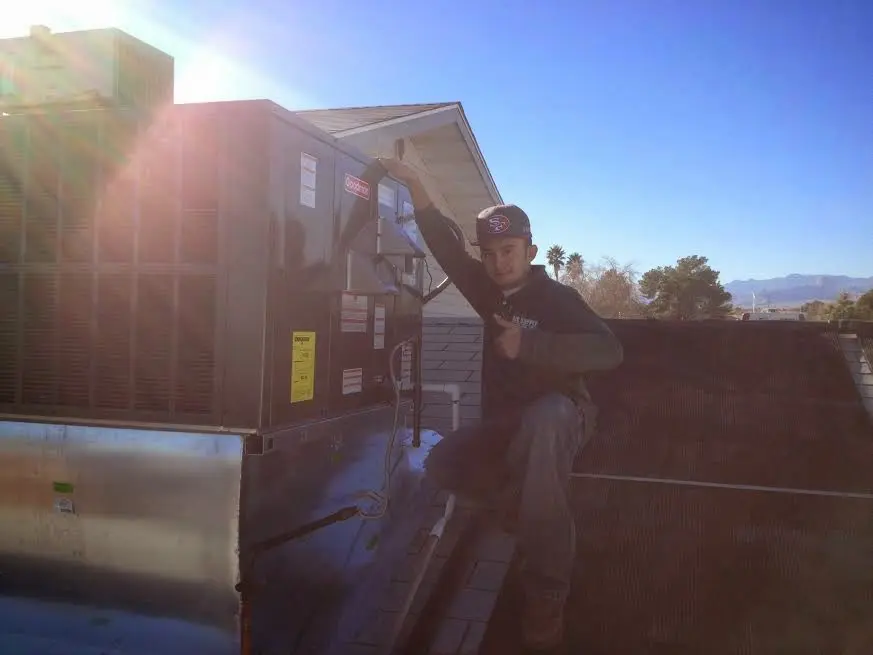 HVAC technician performing HVAC Inspection on a rooftop unit in White Center